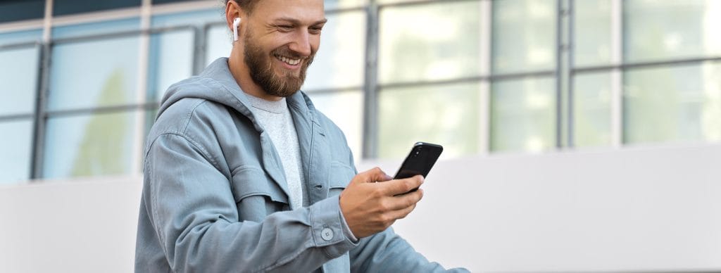 Getting a new iPhone doesn't have to be expensive - Man Happy Smiling with his new phone